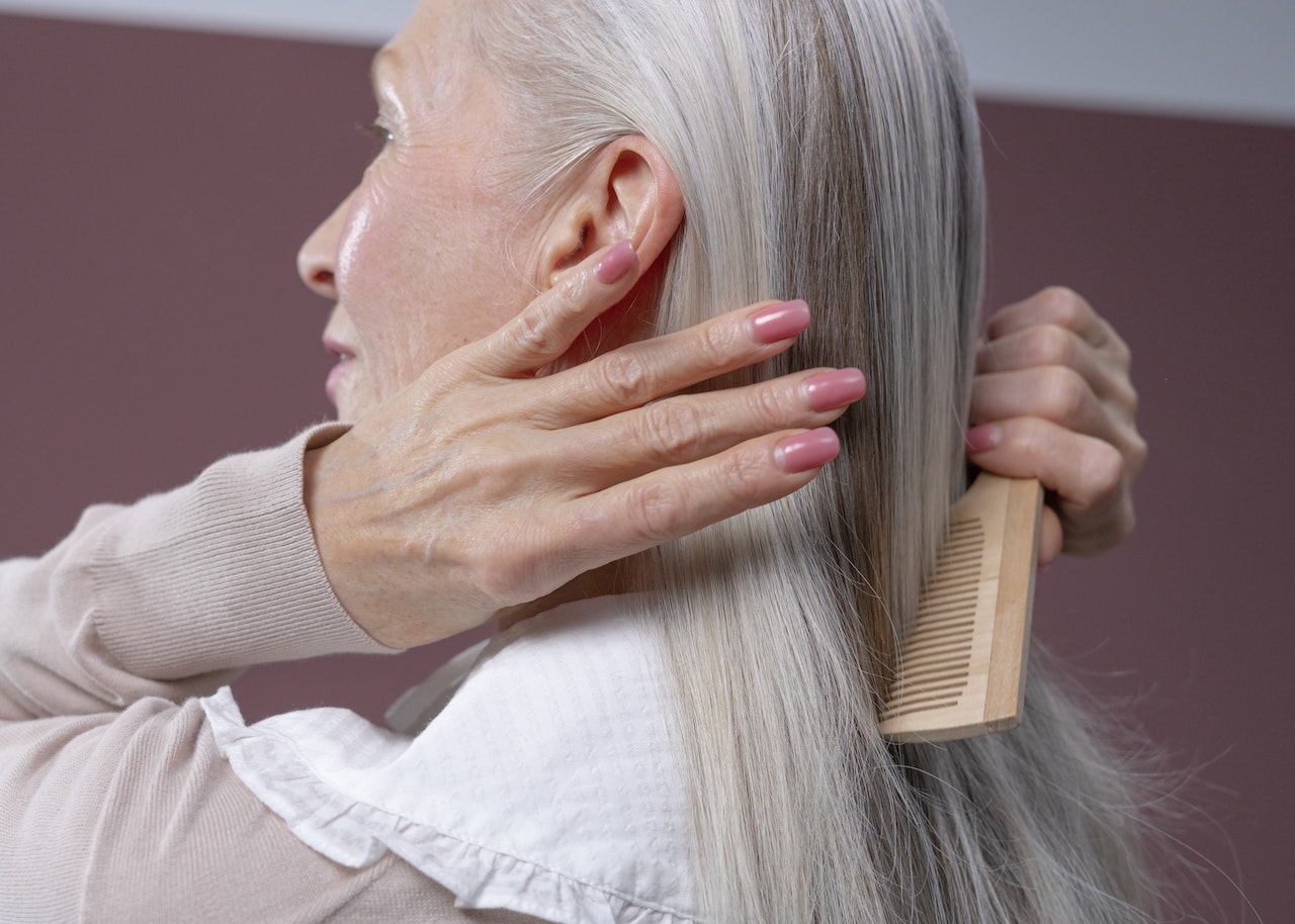 elderly woman combing her hair